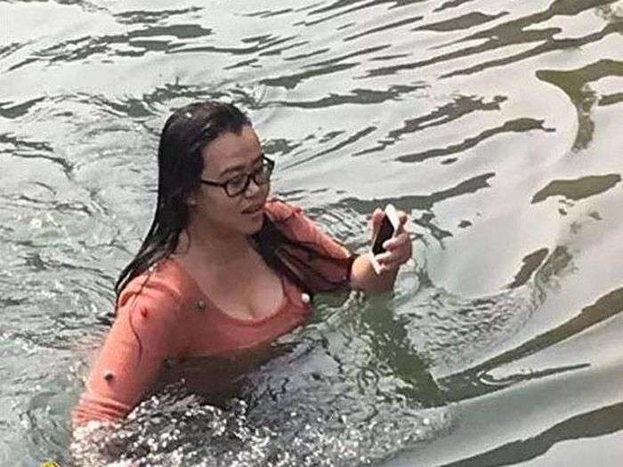 Китаянка пірнула в крижану воду, щоб дістати впав iPhone (4 фото)